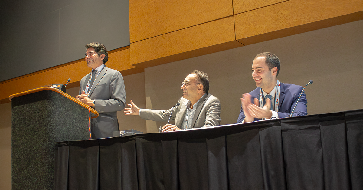 Panelists applauding speaker on podium