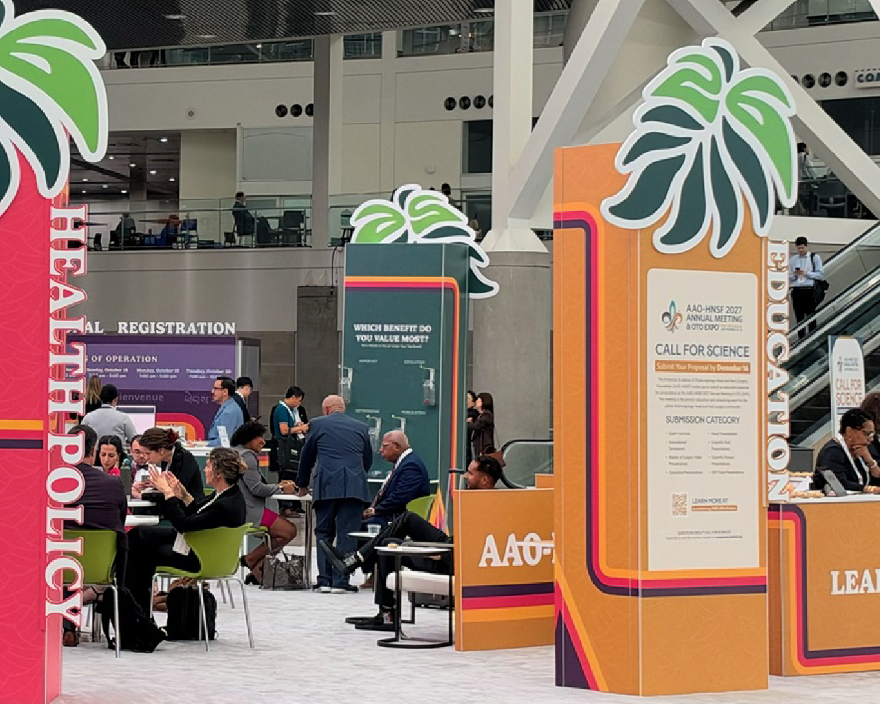 Attendees walking through a wide convention hall concourse lined with tall AAO-HNS vertical banners.