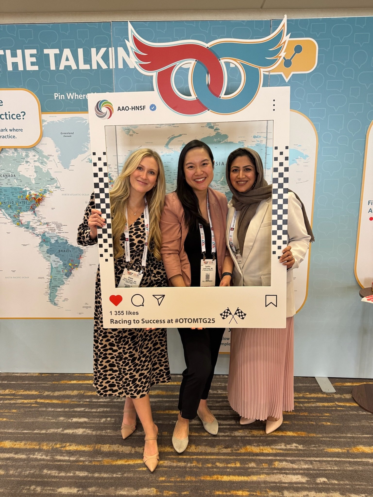 3 attendees taking photo in prop frame