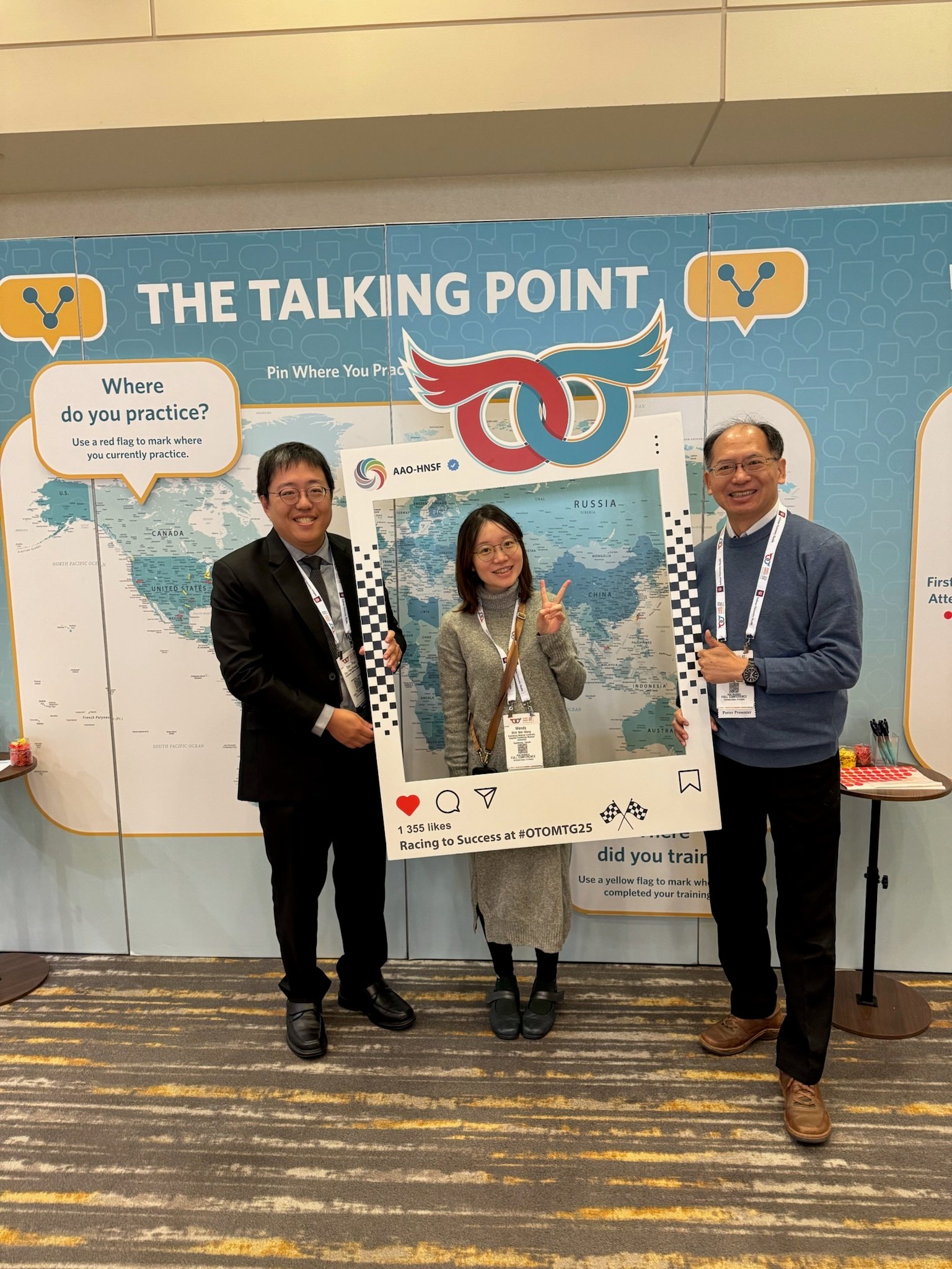 3 attendees taking photo with prop frame