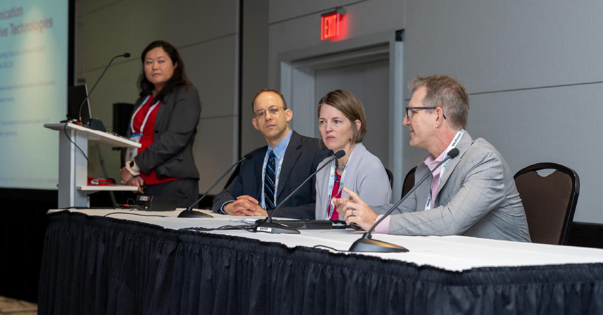 Photo of an education session panel featuring four speakers
